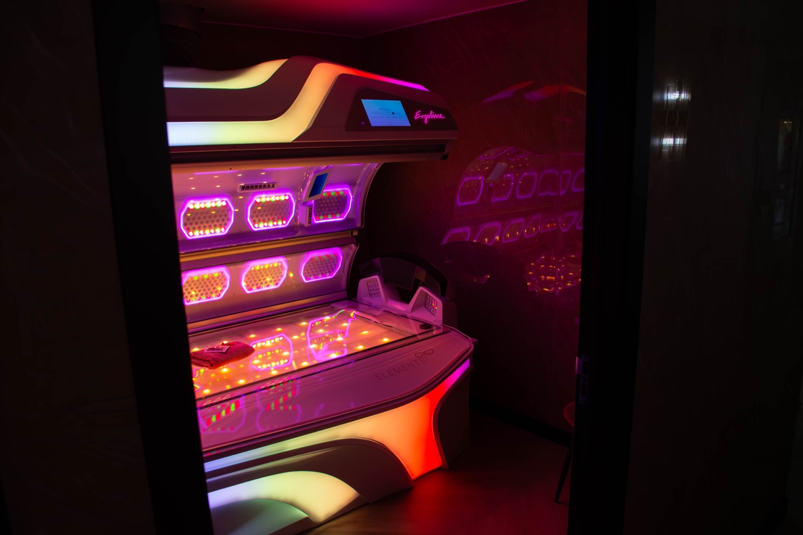 De cabine van Zonnestudio Sneek met de Ergoline Elements zonnebank open en verlicht